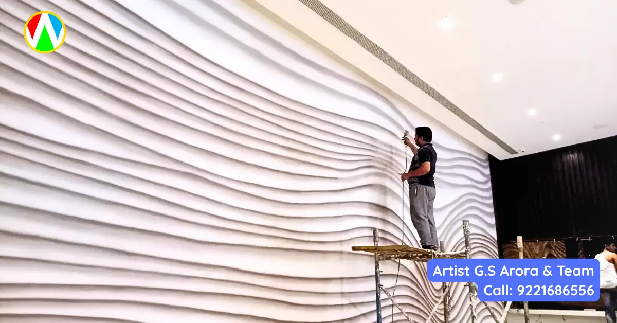 Artist G.S. Arora working on scaffolding to create a massive 3D wave texture wall art for a commercial interior