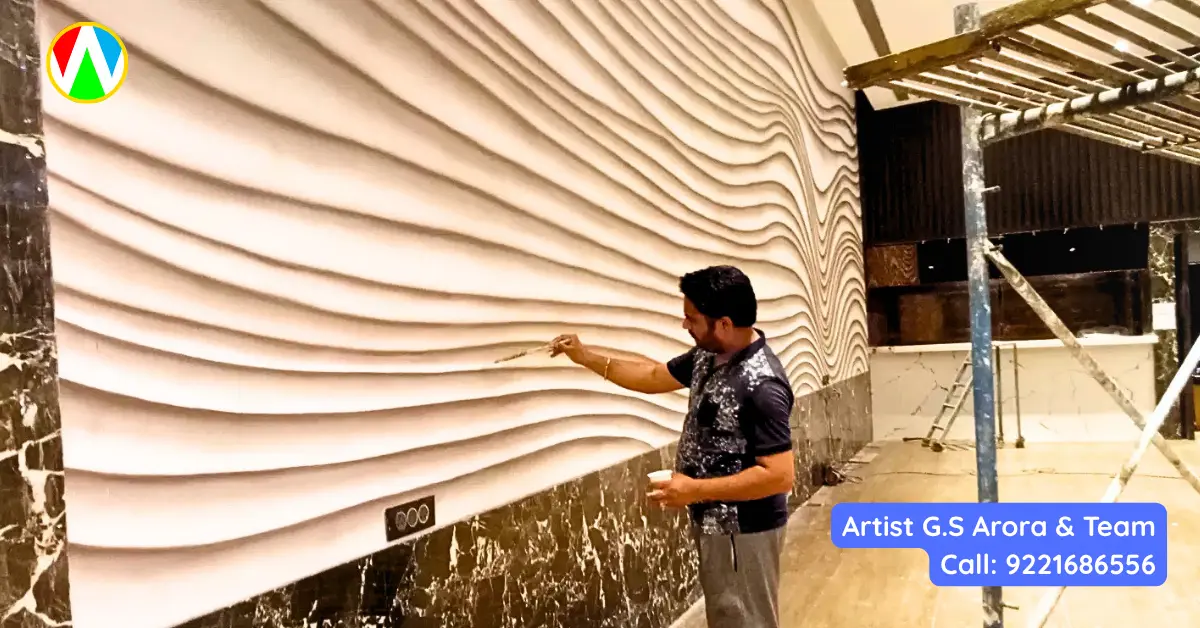 Professional mural artist using a spray gun to apply base layers on a large 3D textured wave wall painting