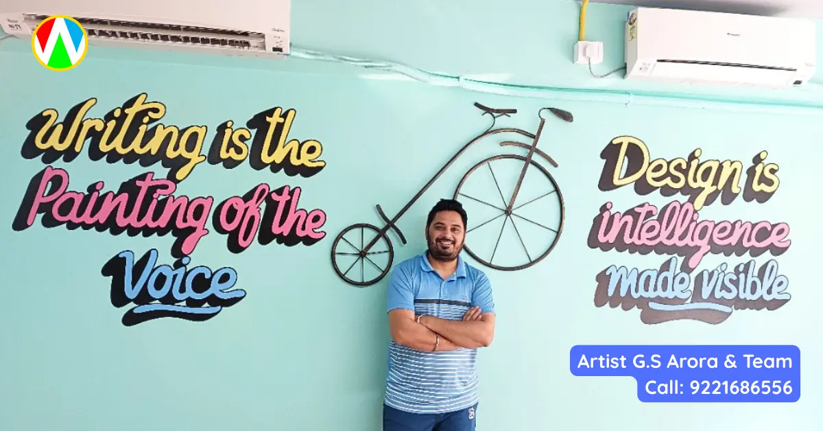 Artist G.S. Arora standing in front of spectacular custom office typography murals in a modern corporate interior