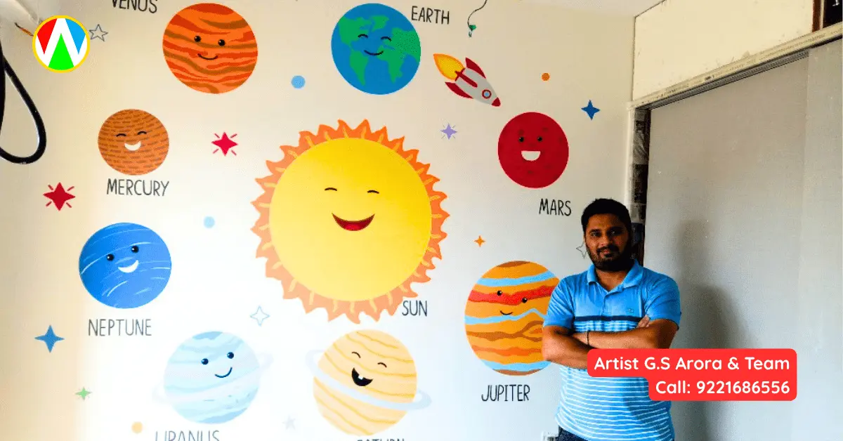 Artist G.S. Arora posing with the finished cute solar system wall mural